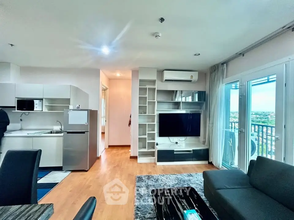 Modern living room with open kitchen and balcony view in a stylish apartment