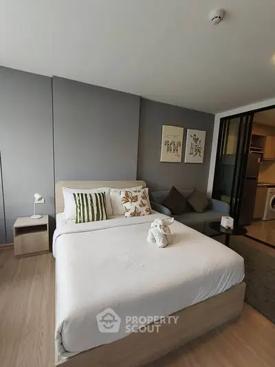Modern bedroom with cozy decor and adjacent living area in stylish apartment.