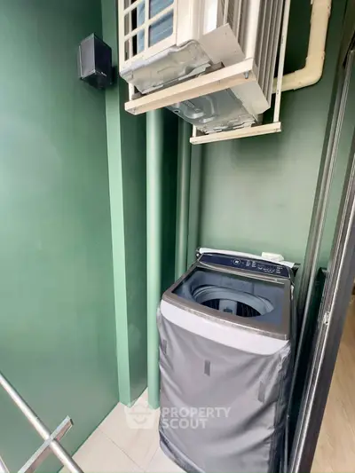 Compact balcony with washing machine and air conditioning unit, ideal for urban living.