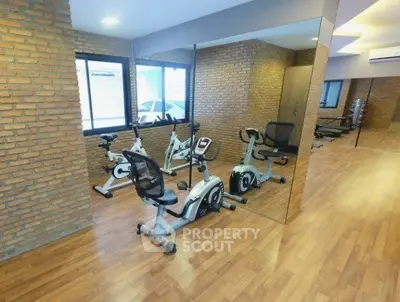Modern gym with exercise bikes and mirrored walls in a stylish apartment complex.
