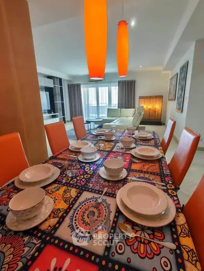 Spacious dining area with vibrant table setting and modern lighting in a stylish open-plan living room.