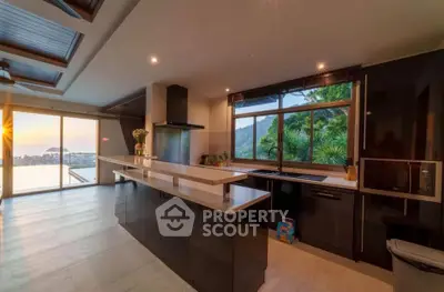 Luxurious modern kitchen with stunning sunset view and sleek black cabinetry.