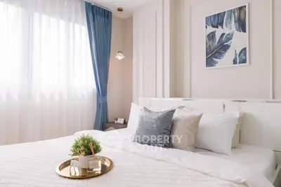 Elegant bedroom with plush pillows and stylish decor, featuring soft lighting and a serene atmosphere.