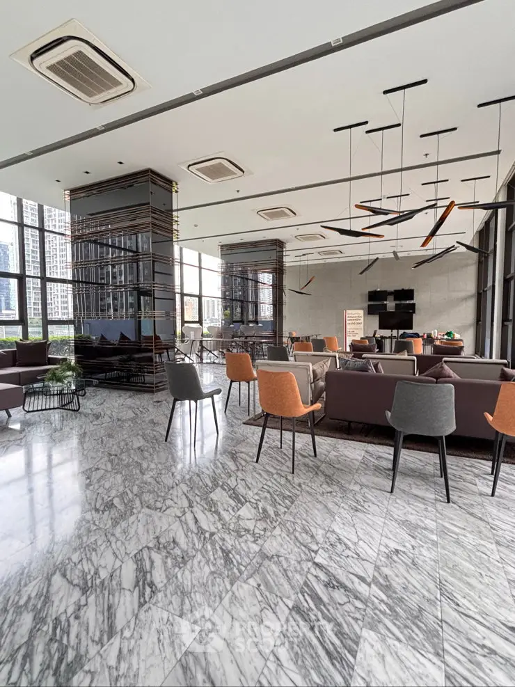 Luxurious modern lobby with marble flooring and stylish seating in high-rise building.