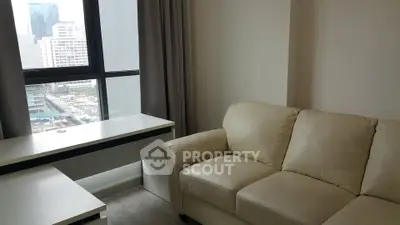 Modern apartment interior with cozy beige sofa and city view from window.