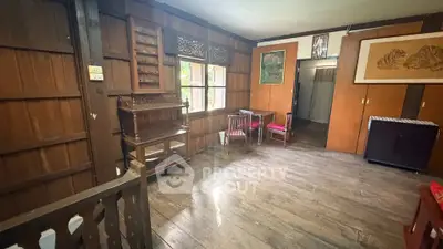 Charming rustic living room with wooden walls and vintage furniture, perfect for cozy gatherings.