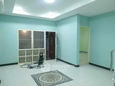 Spacious living room with modern design and tiled flooring, perfect for family gatherings.