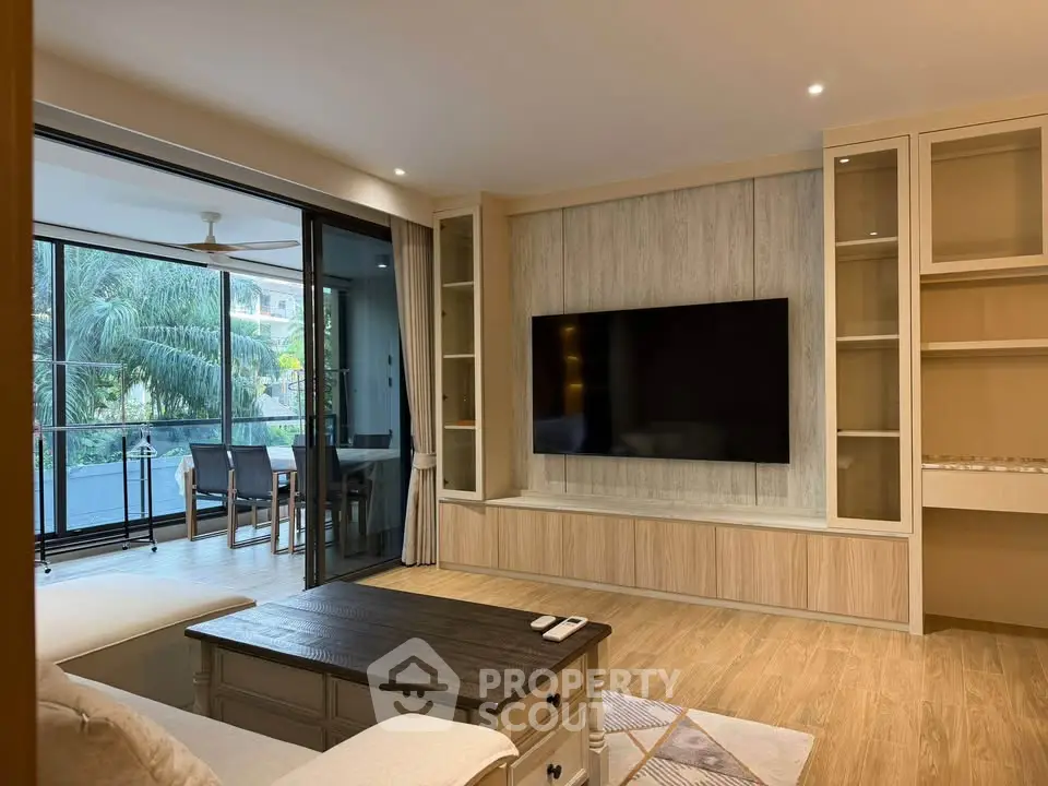 Modern living room with large TV and balcony view in luxury apartment