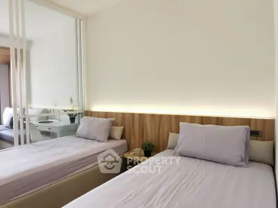 Modern twin bedroom with mirrored closet and soft lighting