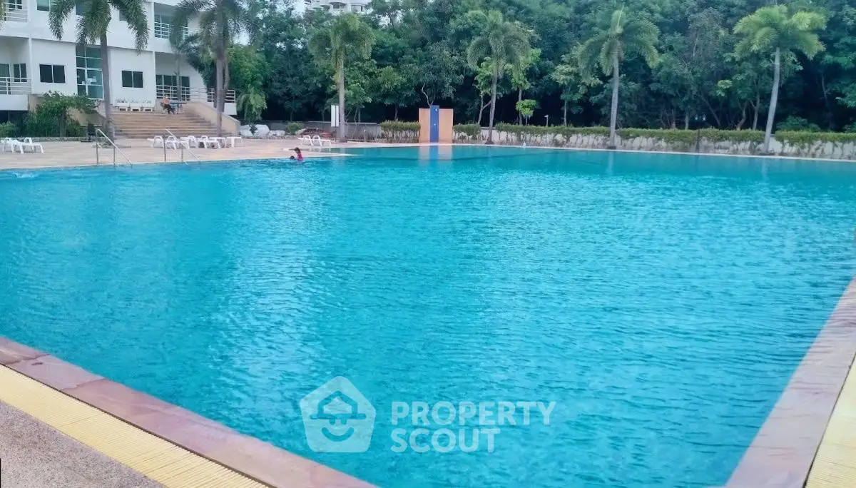 Luxurious residential pool with lush greenery and modern architecture.