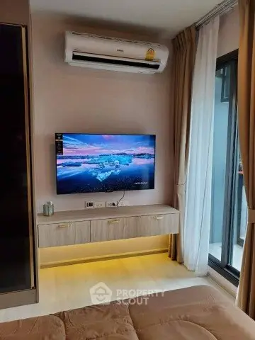 Modern living room with wall-mounted TV and air conditioning, featuring a sleek design and natural light.