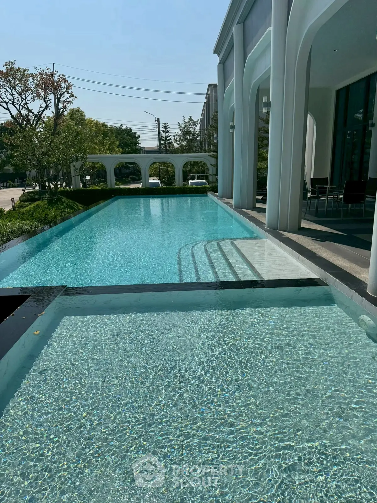 Luxurious outdoor pool with elegant architecture and serene surroundings, perfect for relaxation and leisure.