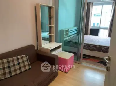 Cozy apartment interior with a compact living area and bedroom, featuring modern furniture and natural light.