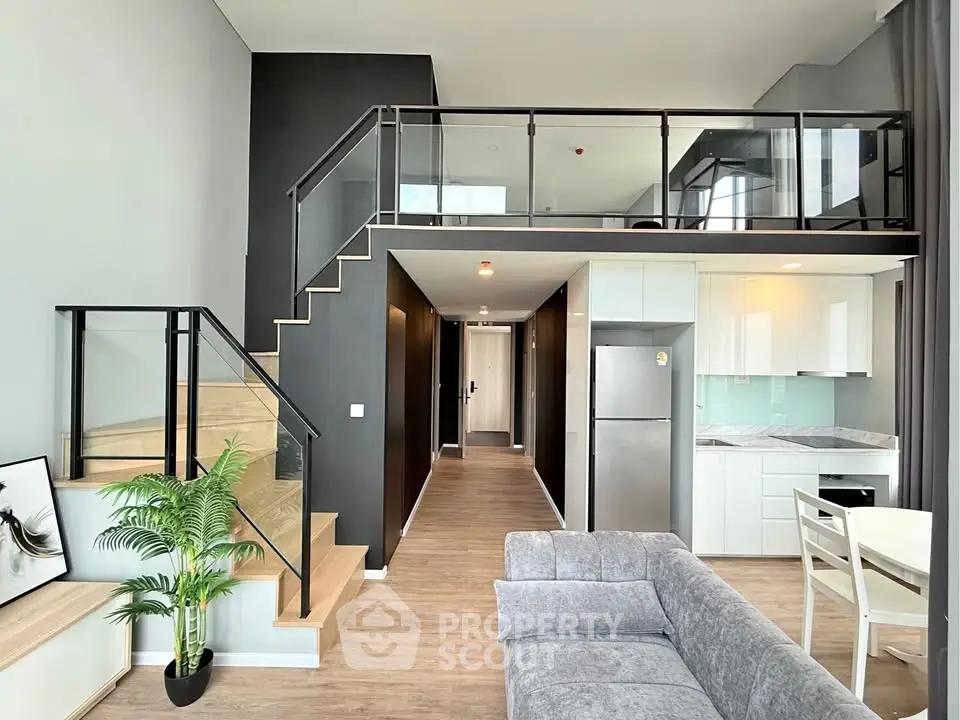 Modern loft apartment with sleek design, featuring open layout, stylish staircase, and contemporary kitchen.