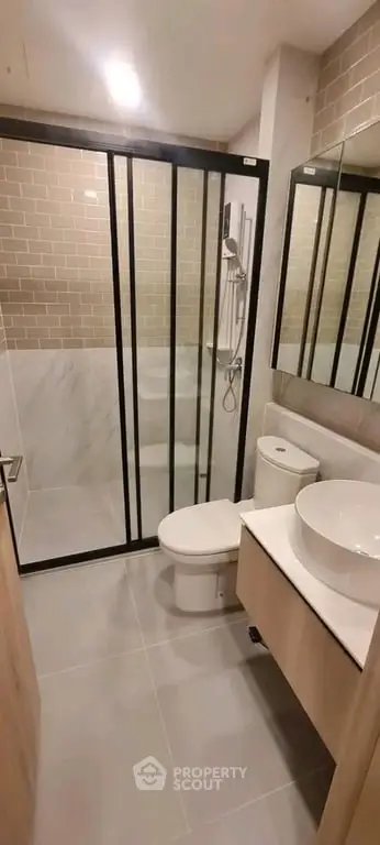 Modern bathroom with sleek shower enclosure and stylish vanity in contemporary apartment.