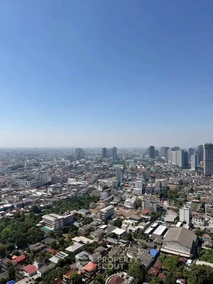 Stunning panoramic cityscape view from a high-rise building, showcasing urban skyline and clear blue sky.