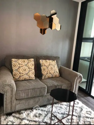 Cozy living room with plush sofa, decorative pillows, and modern wall art in a stylish apartment.