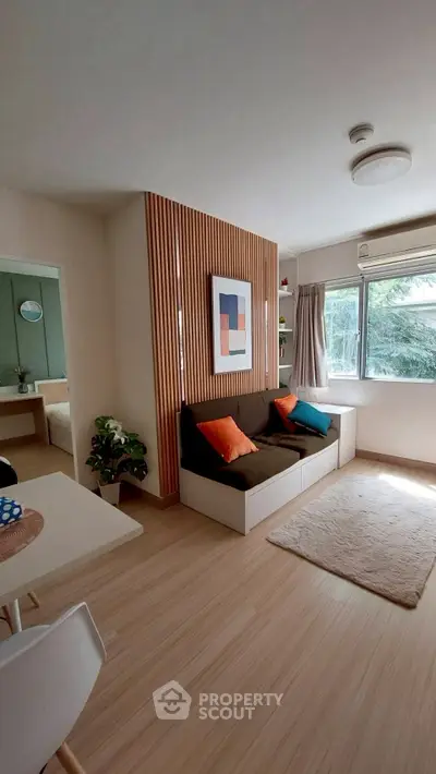 Charming living room with modern decor and natural light, featuring cozy seating and stylish wooden accents.