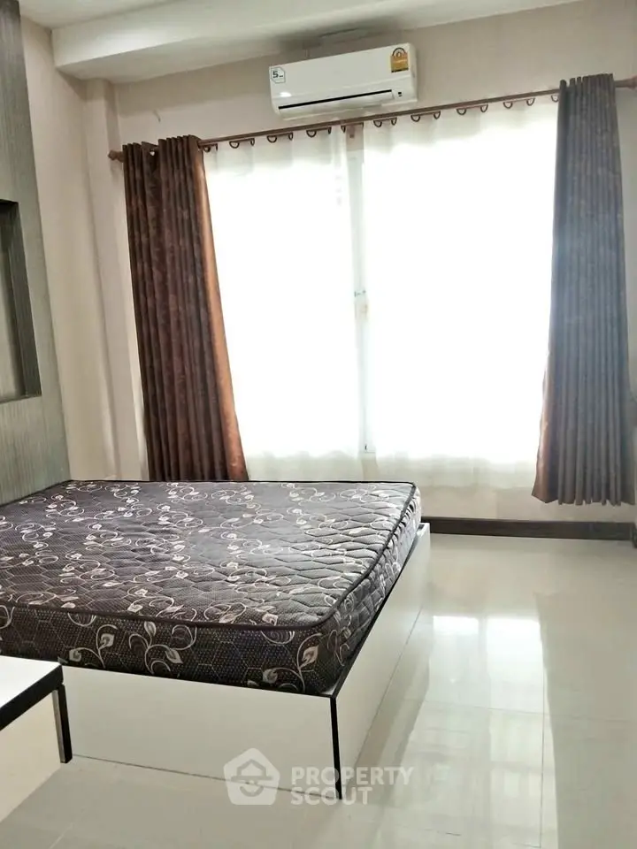 Bright bedroom with large window and modern furnishings in a stylish apartment.