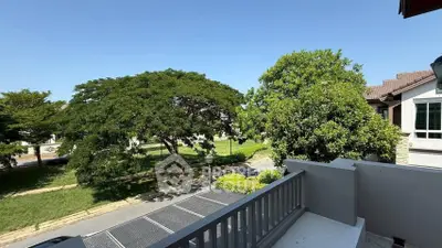 Charming balcony view overlooking lush greenery and a quiet street, perfect for relaxation.