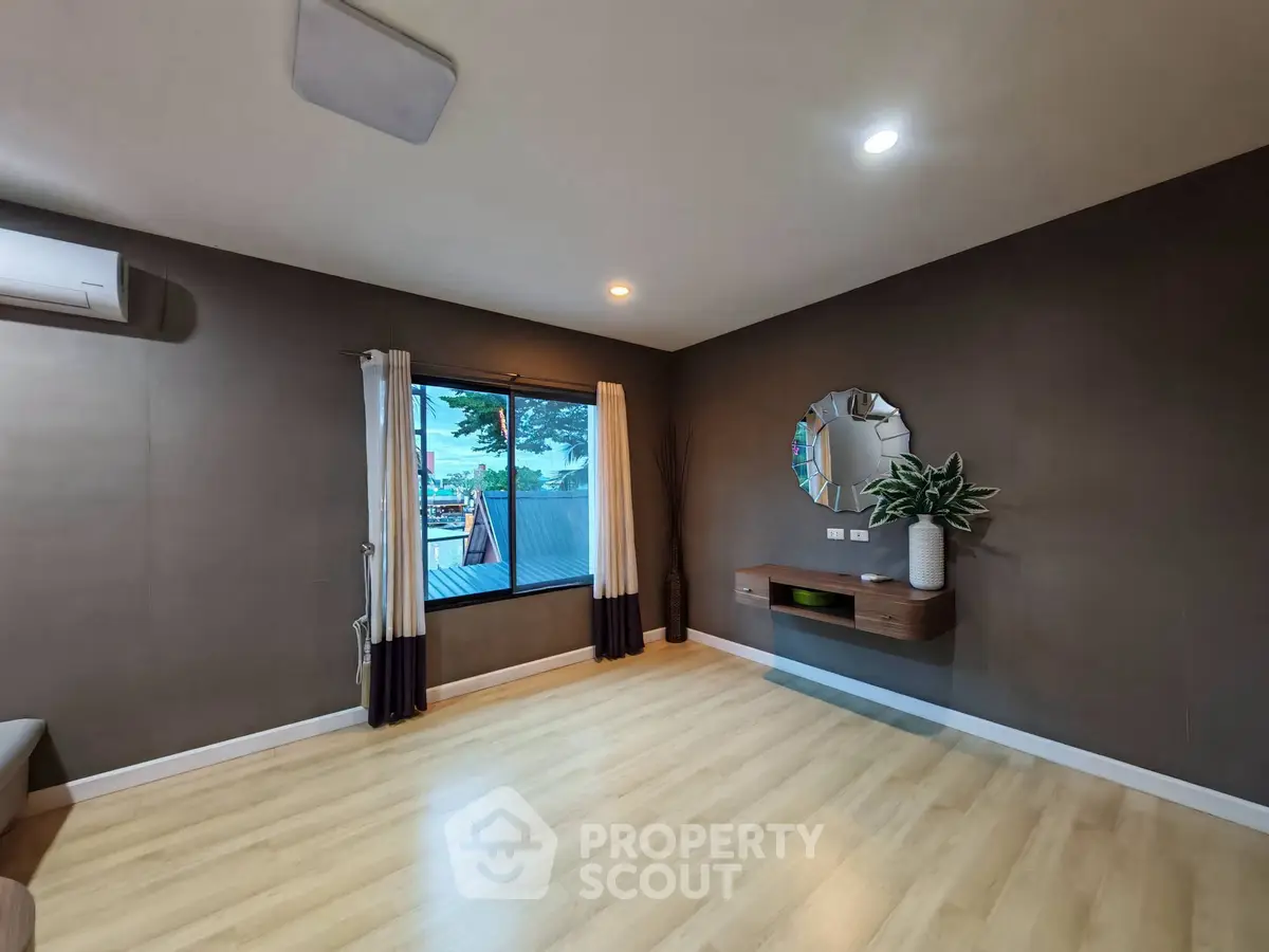 Spacious living room with modern decor and large window offering scenic views.