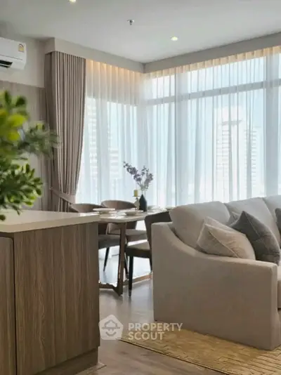 Modern living room with elegant decor and large windows offering city views