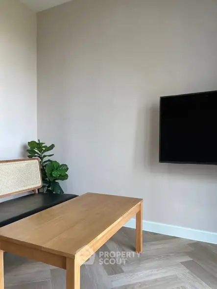 Modern living room with sleek wooden table and wall-mounted TV, perfect for stylish urban living.