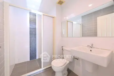 Modern bathroom with sleek shower and elegant fixtures in a bright, minimalist design.