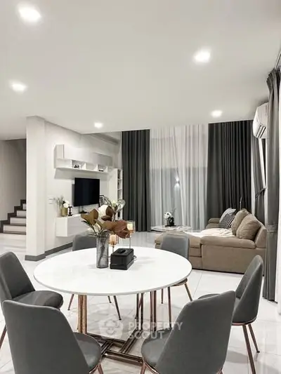 Modern living room with elegant decor, spacious seating, and stylish dining area.