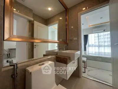 Modern bathroom with elegant fixtures and a view into a stylish bedroom