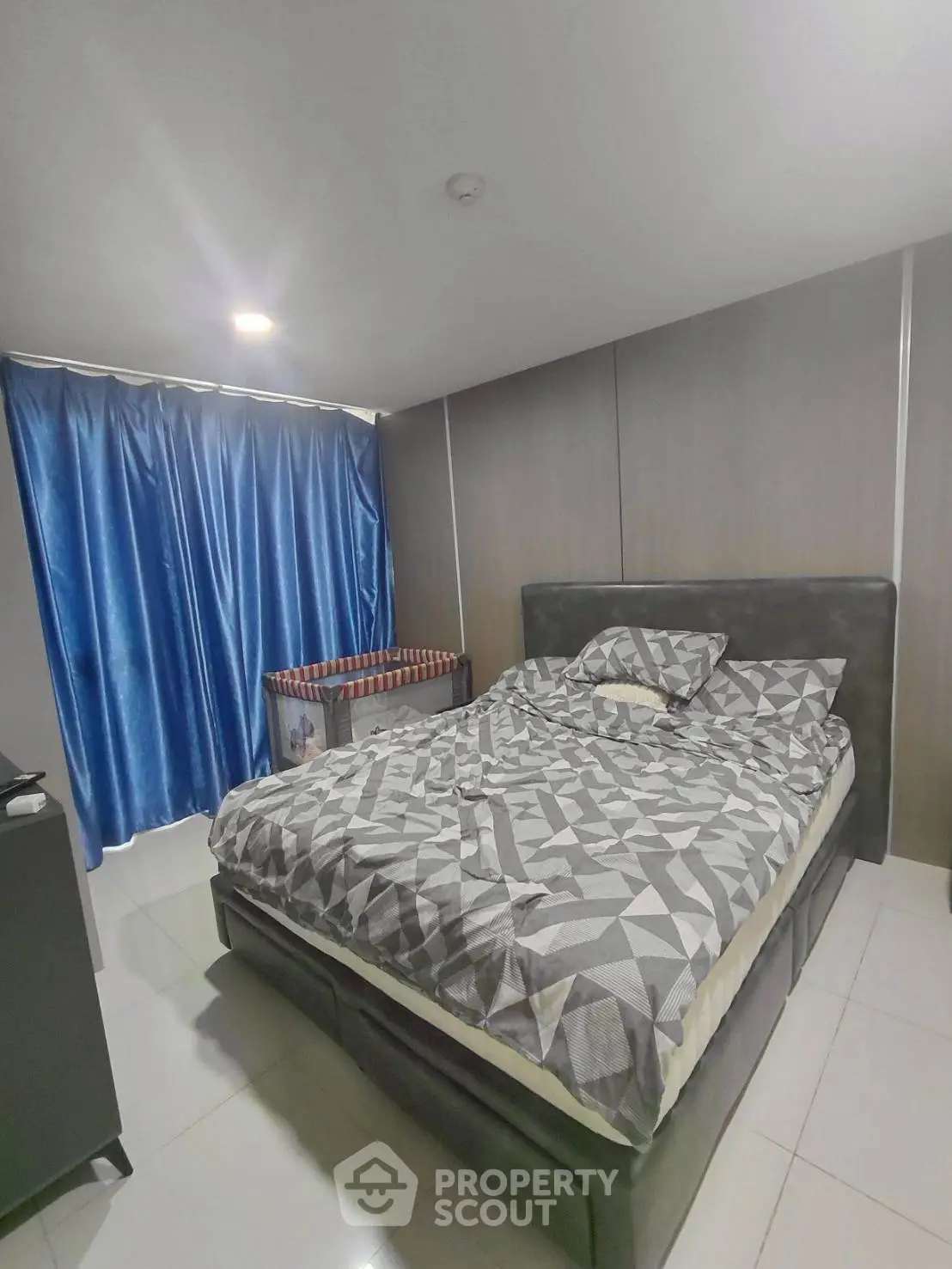 Modern bedroom with stylish decor and cozy bedding in a contemporary apartment.