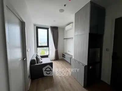 Modern compact living room with large window and sleek furniture