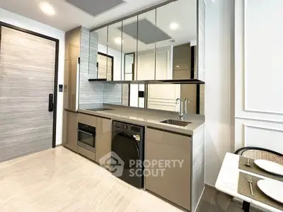 Modern kitchen with sleek cabinetry, built-in appliances, and elegant dining area in a contemporary apartment.