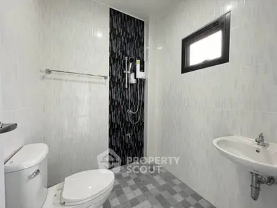 Modern bathroom with sleek black accent wall and white fixtures