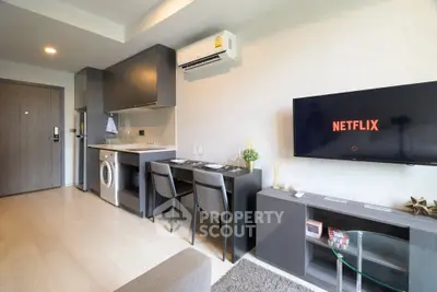 Modern apartment interior with sleek kitchen and cozy living area featuring Netflix on TV.