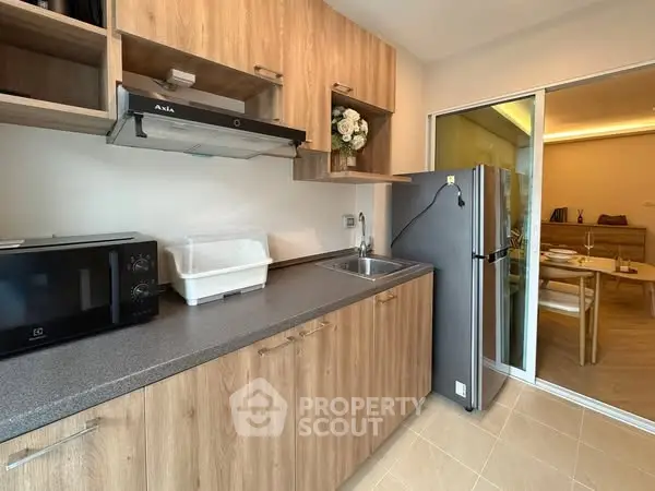 Modern kitchen with wooden cabinets and stainless steel appliances in cozy apartment