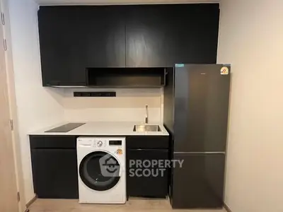 Modern compact kitchen with sleek black cabinets and integrated appliances