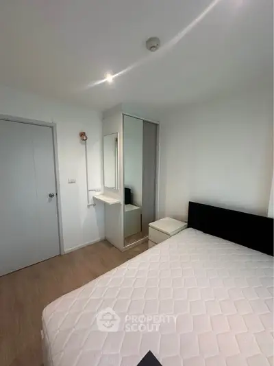 Modern bedroom with minimalist design featuring a comfortable bed and sleek wardrobe.