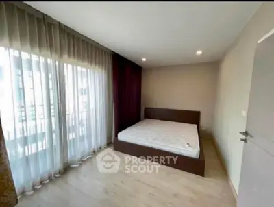 Spacious bedroom with large windows and natural light