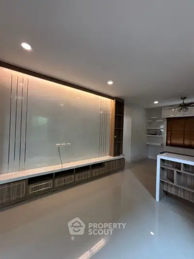 Modern living room with sleek built-in storage and open kitchen layout
