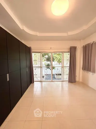 Spacious room with large windows and built-in wardrobe, perfect for modern living.
