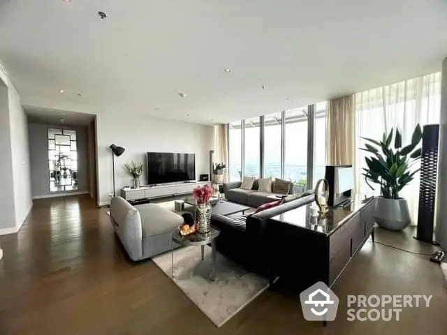 Expansive luxury living room with floor-to-ceiling windows offering panoramic views, modern furnishings, and hardwood floors.