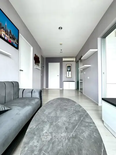 Modern living room with sleek gray sofa and stylish decor in a contemporary apartment.