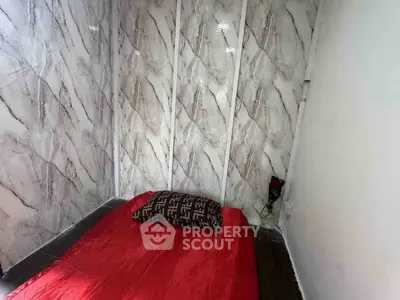 Cozy bedroom with marble accent wall and red bedding