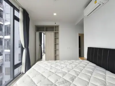 Modern bedroom with large windows and built-in wardrobe in high-rise apartment