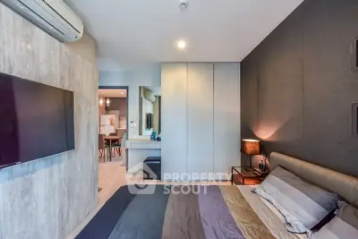 Modern bedroom with stylish decor and wall-mounted TV in a contemporary apartment.