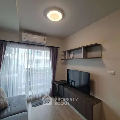 Modern living room with balcony, featuring sleek furniture and natural light.