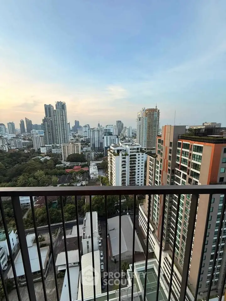 Stunning cityscape view from high-rise balcony overlooking urban skyline and lush greenery.