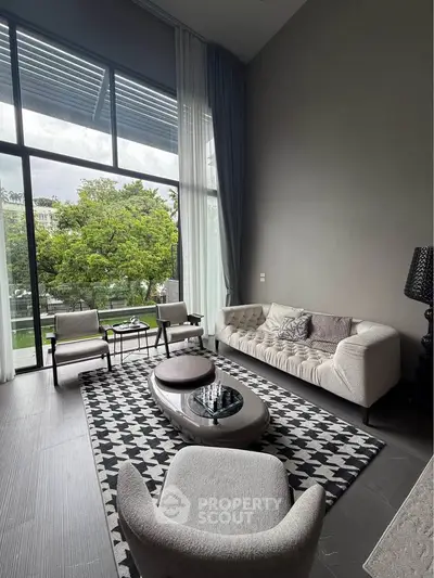 Luxurious living room with high ceilings and large windows offering a stunning garden view.