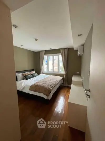 Spacious bedroom with large window and modern decor